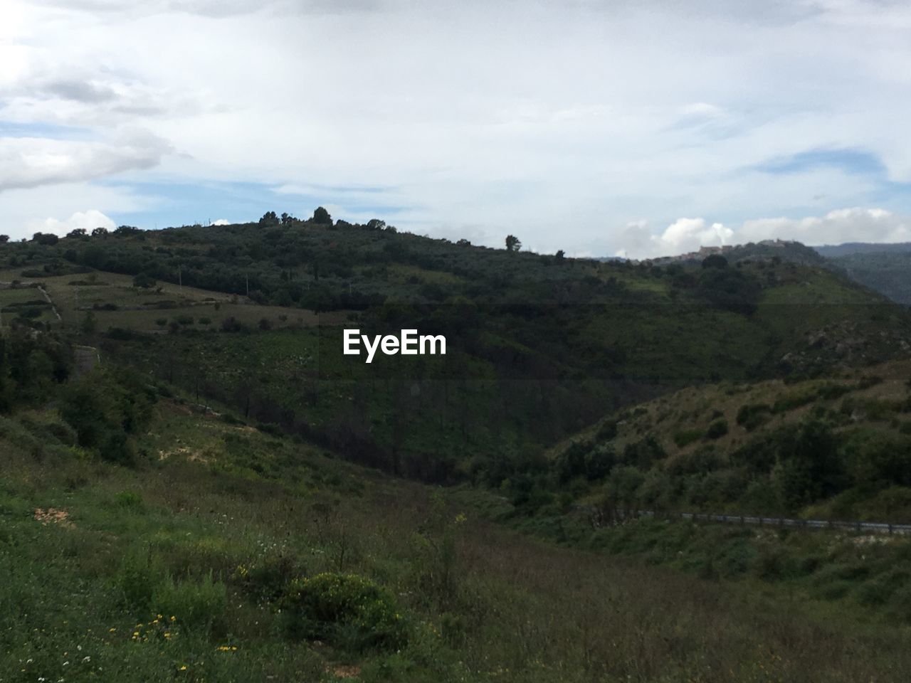 SCENIC VIEW OF GREEN LANDSCAPE AND MOUNTAIN RANGE