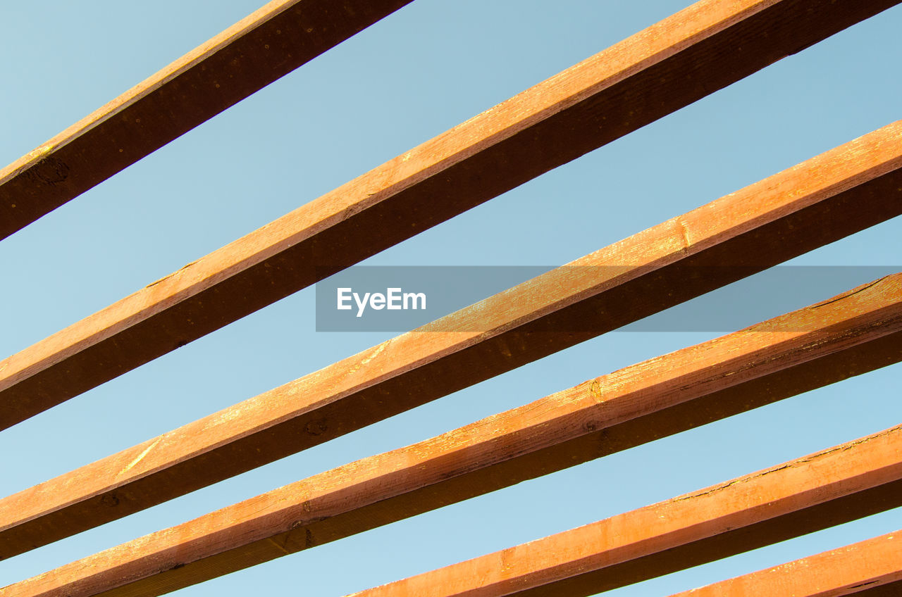 Low angle view of wood against clear blue sky