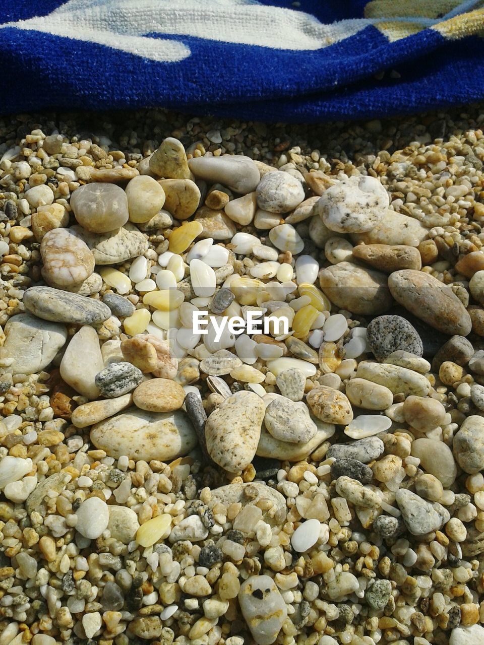 CLOSE-UP OF PEBBLES ON BEACH