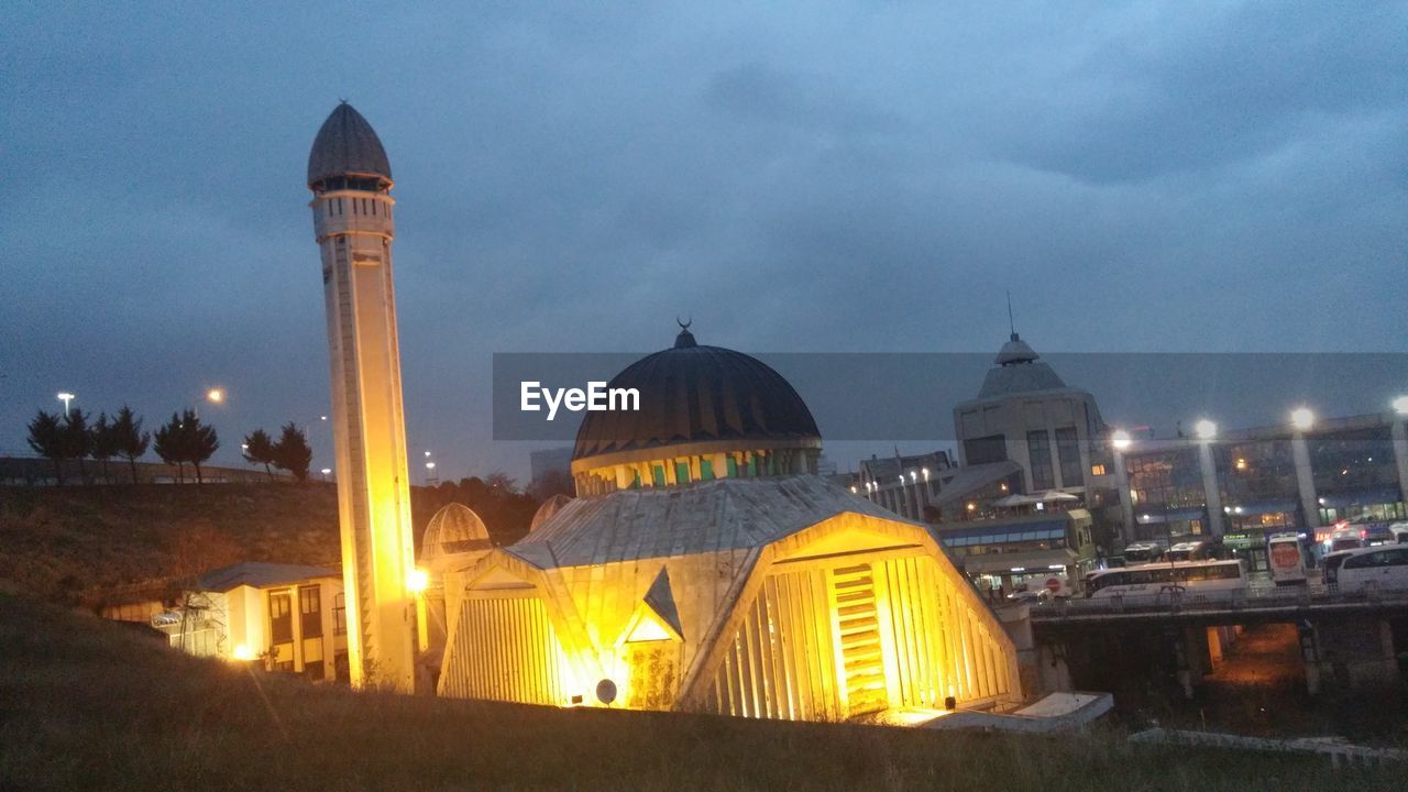 ILLUMINATED MOSQUE AGAINST SKY AT NIGHT