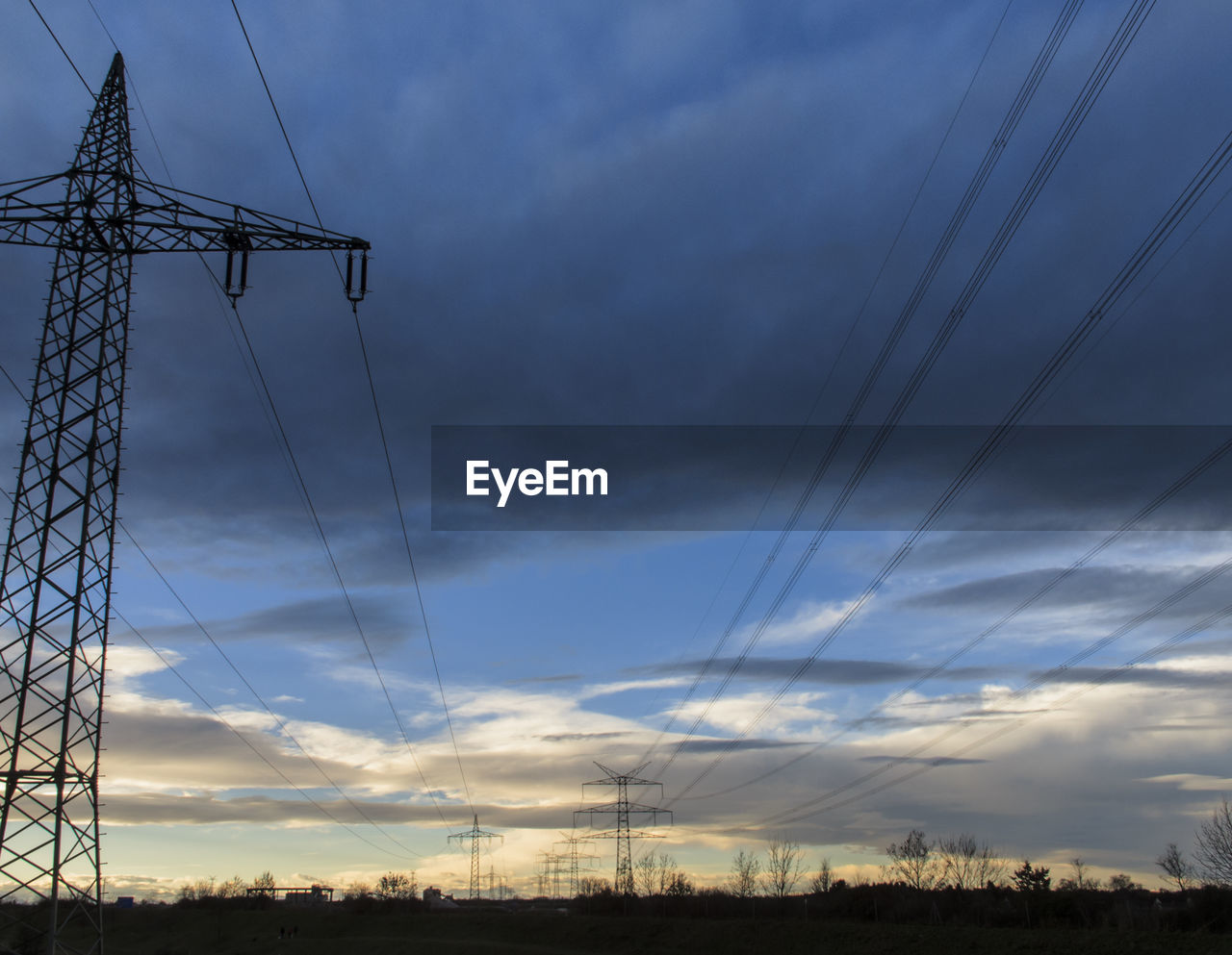 LOW ANGLE VIEW OF ELECTRICITY PYLONS AGAINST SKY DURING SUNSET