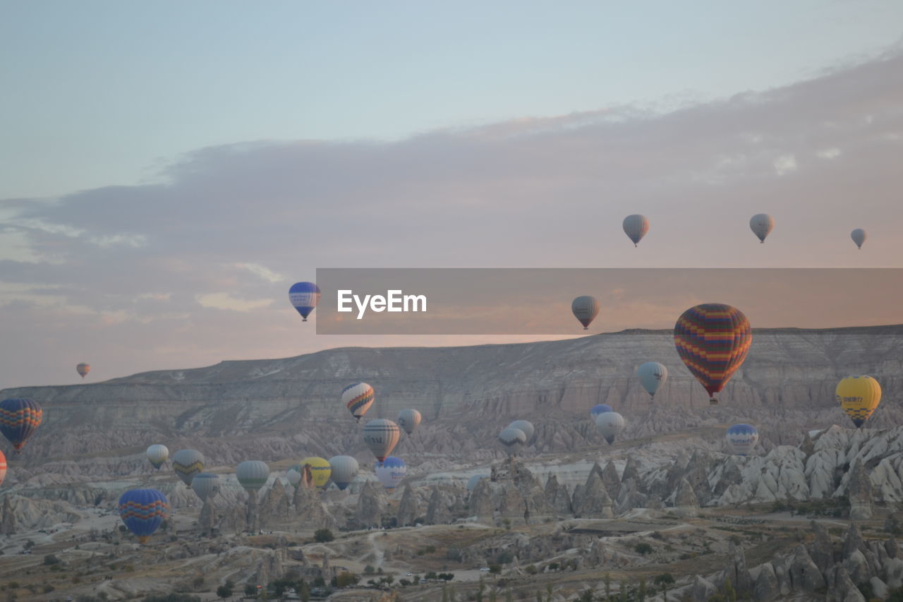 Hot air balloons flying over landscape against sky