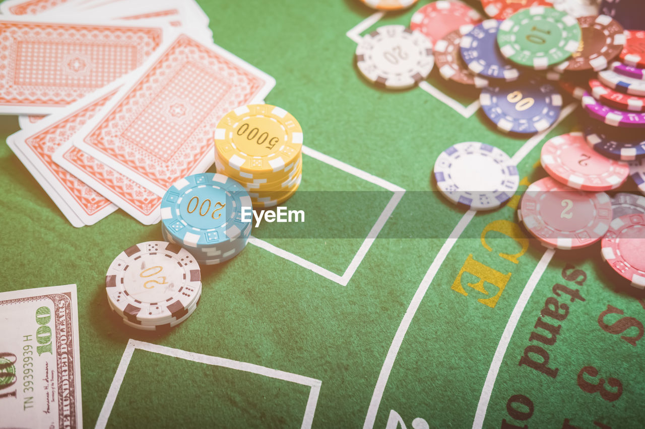 High angle view of gambling chips and cards on blackjack table