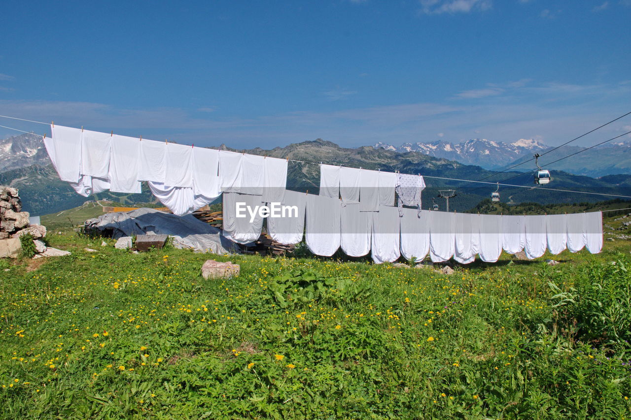 Clothes and sheets drying in the sun on mountain hut in brenta dolomites, italy