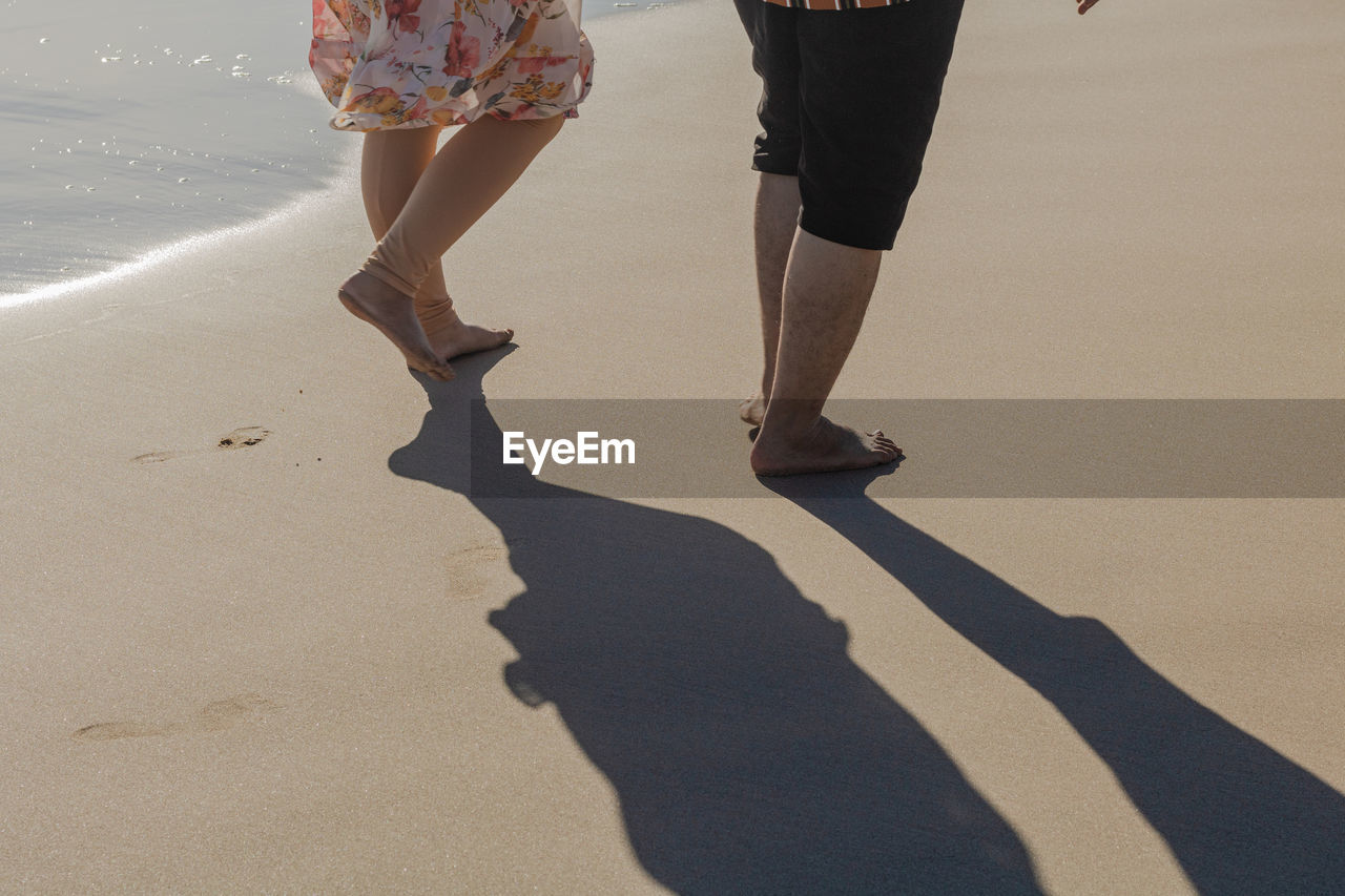 Low section of woman walking on beach