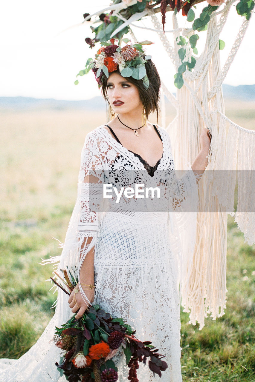 portrait of young woman standing by plants