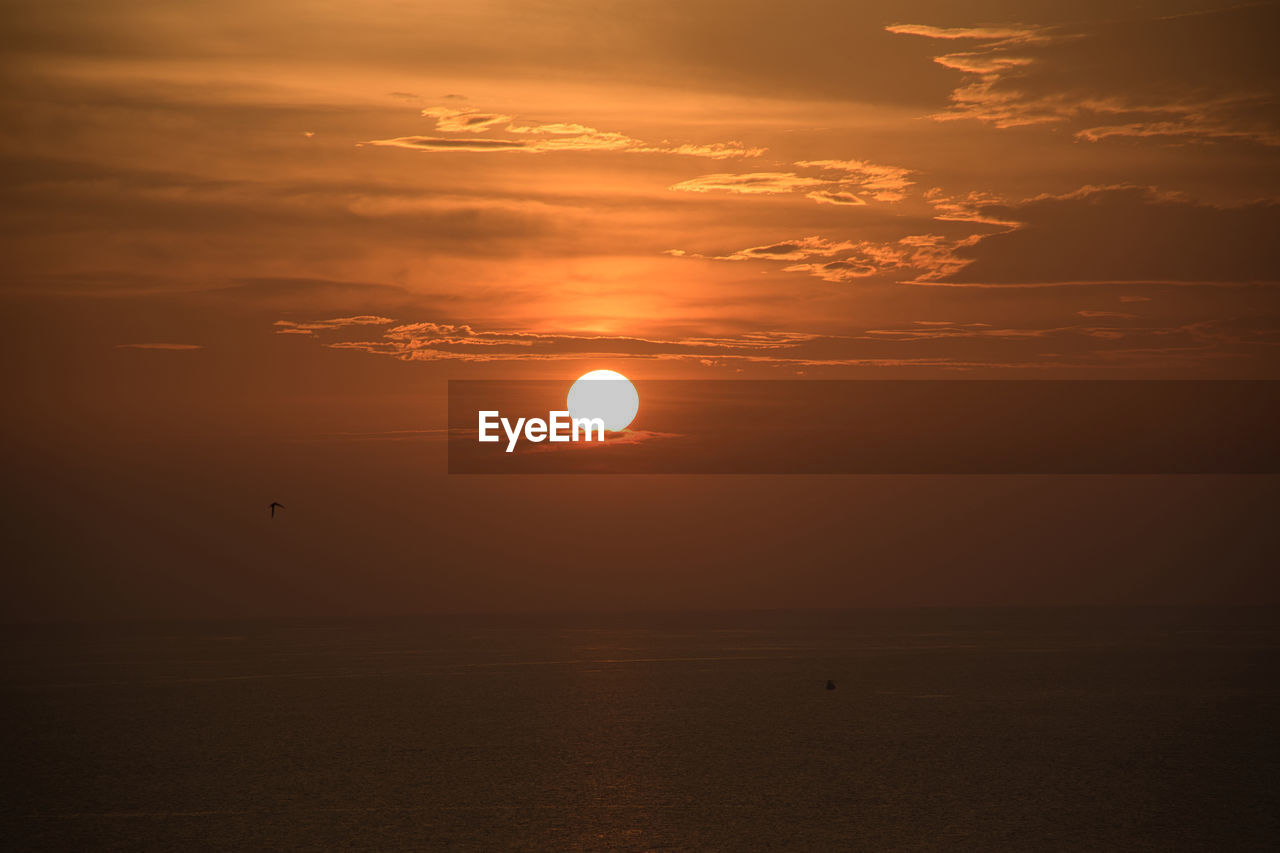 SCENIC VIEW OF SUNSET OVER SEA