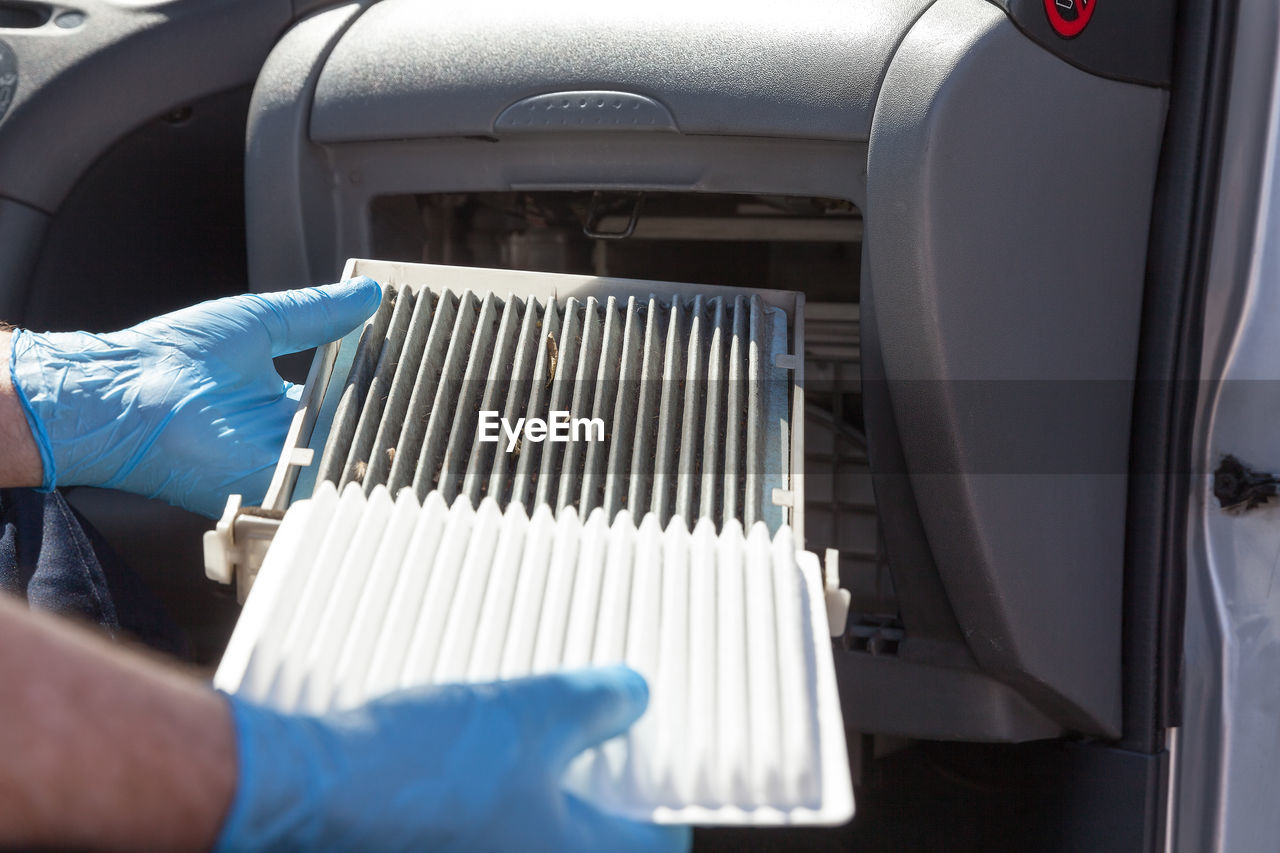Cropped hands of man holding car air filter