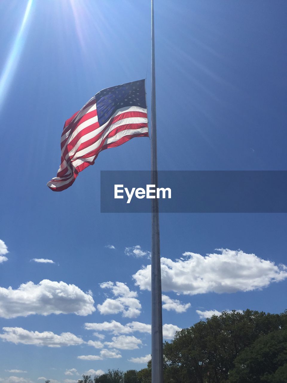 Low angle view of flag against blue sky