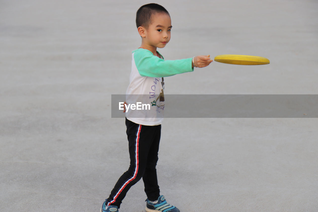 Boy playing with plastic disc at park