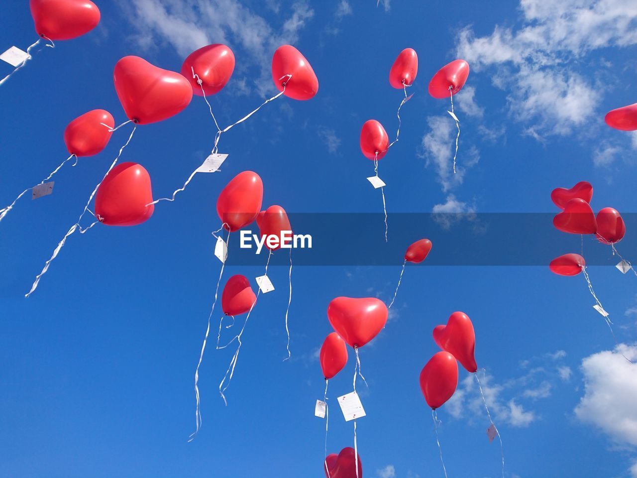 LOW ANGLE VIEW OF BALLOONS IN BLUE SKY