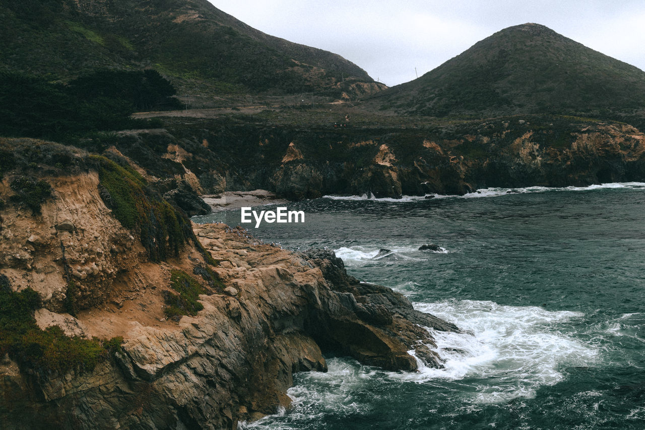 SCENIC VIEW OF SEA AGAINST MOUNTAINS