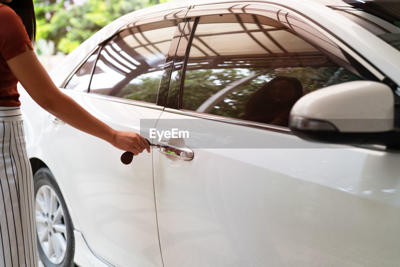 Car unlocks, woman use key to open the car door