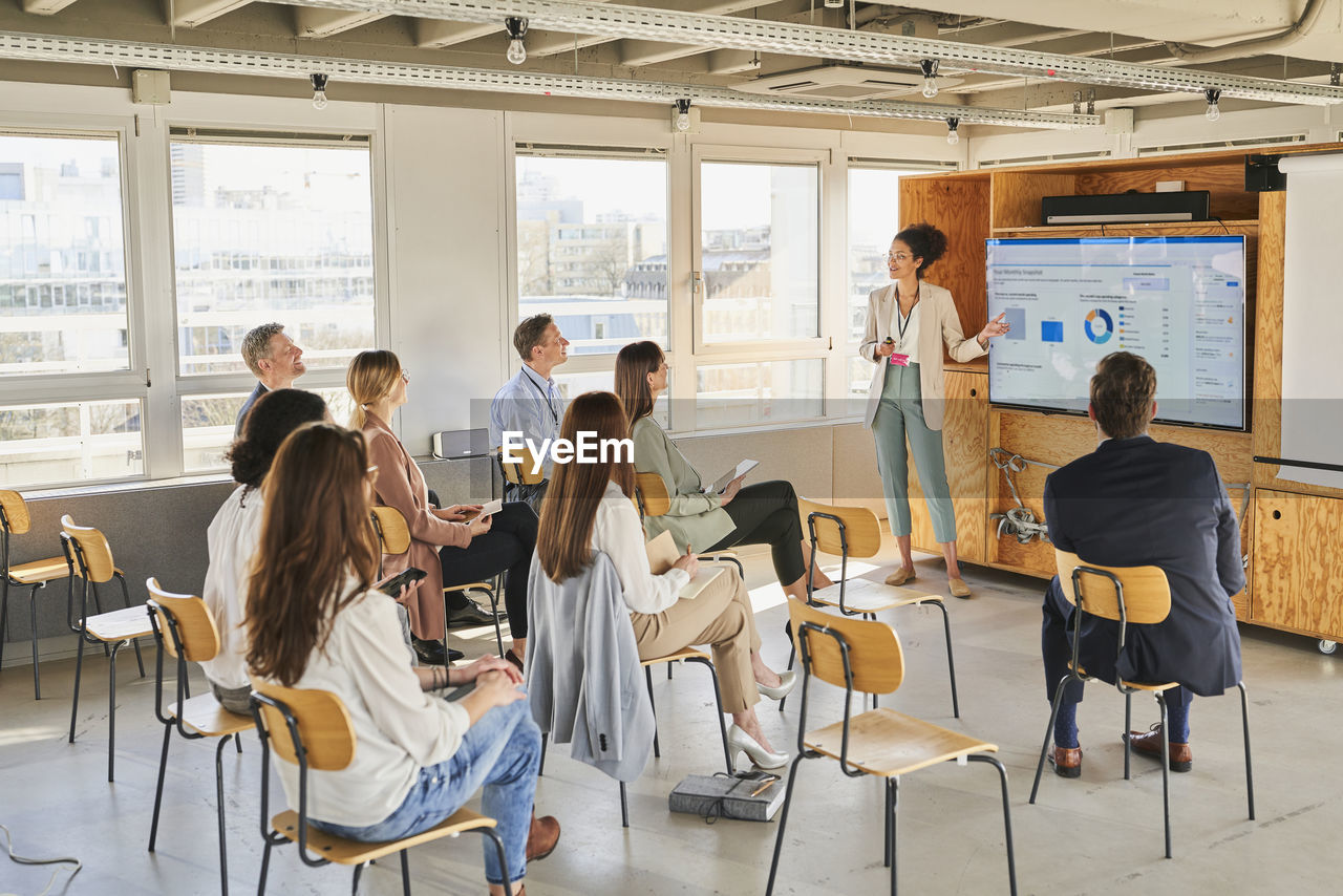 Female professional giving training to colleagues in conference centre