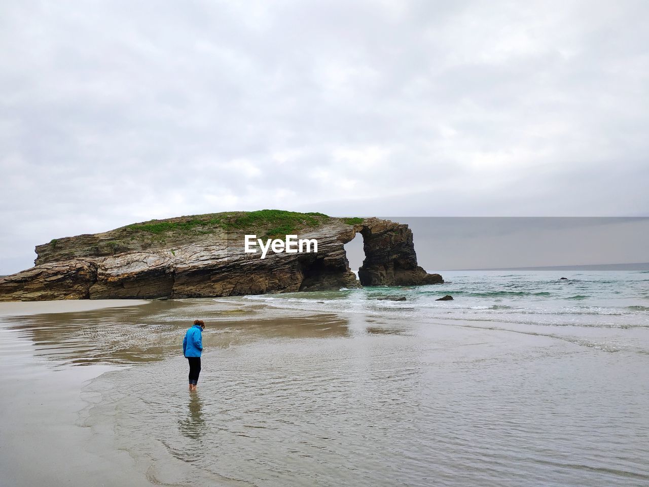 Rear view of woman standing at beach