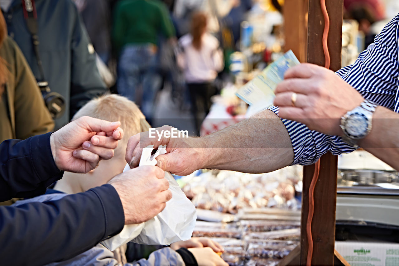 Cropped image of customer buying from vendor at market