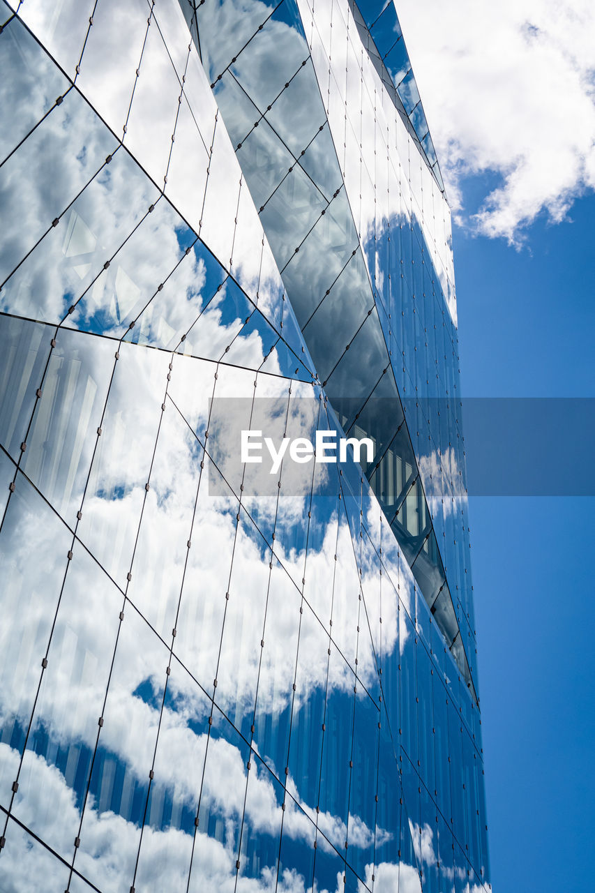 Low angle view of glass building against sky