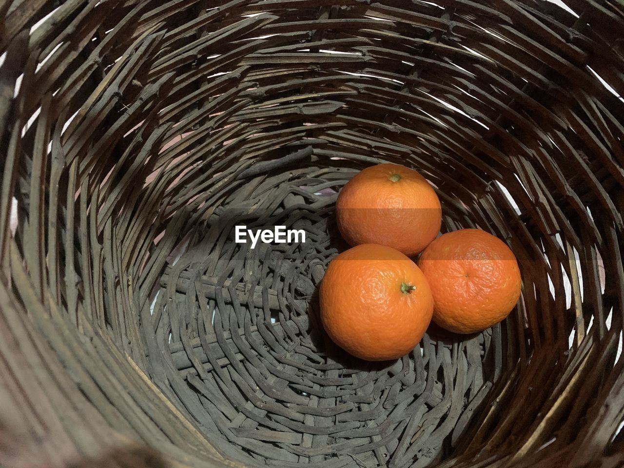 HIGH ANGLE VIEW OF ORANGES IN BASKET