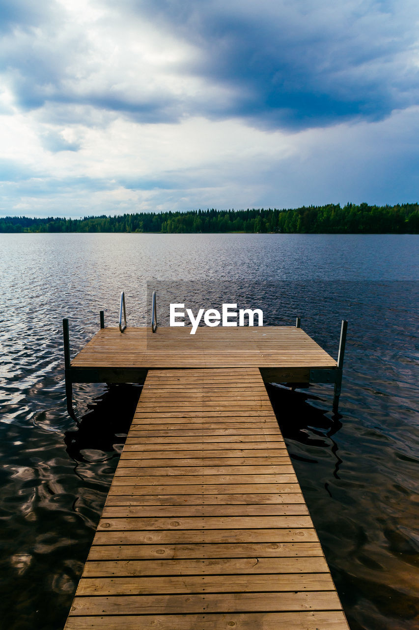 Jetty in lake against sky