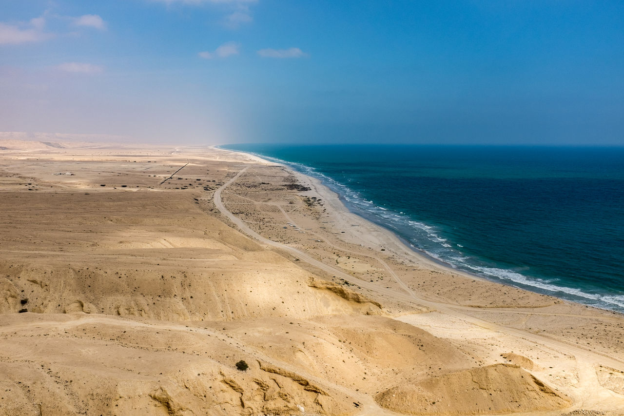 SCENIC VIEW OF BEACH AGAINST BLUE SKY