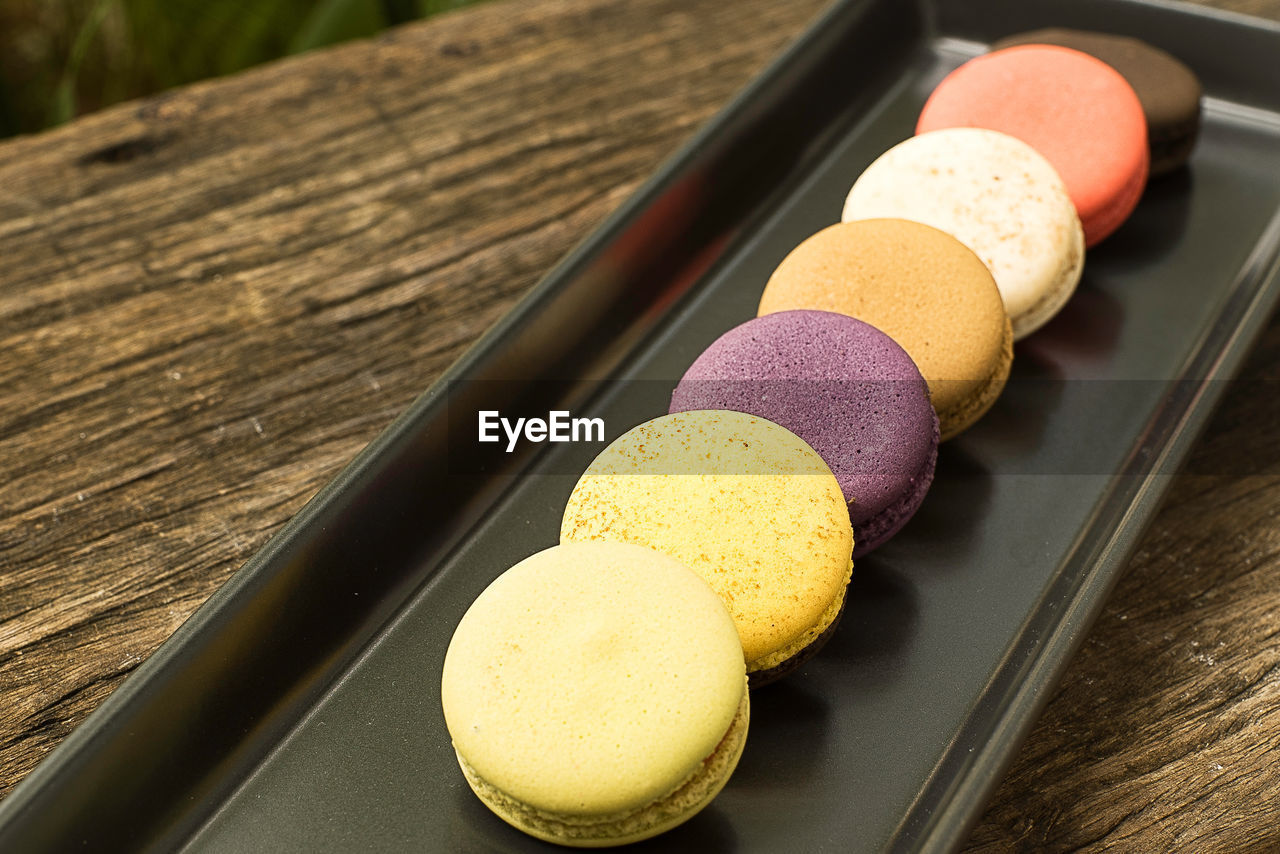 Colorful and delicious french macaron cookies varieties on a wooden table