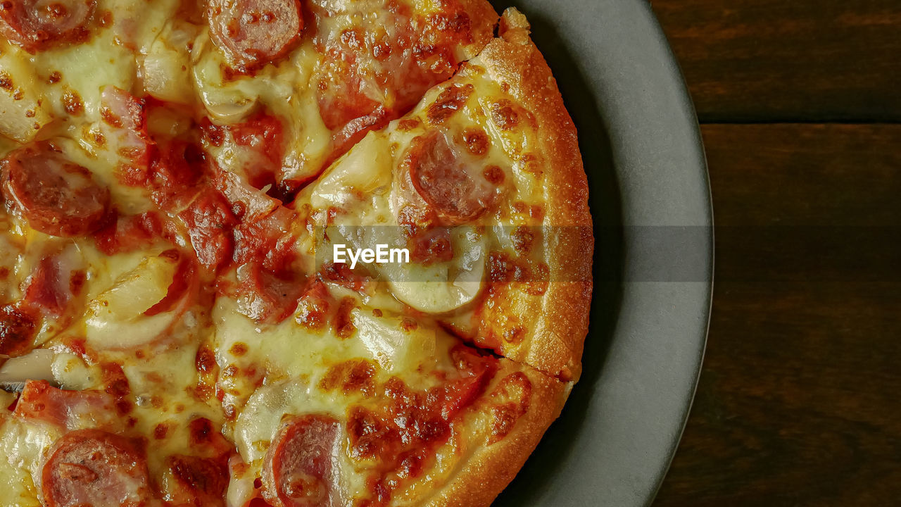 HIGH ANGLE VIEW OF PIZZA IN PLATE ON TABLE