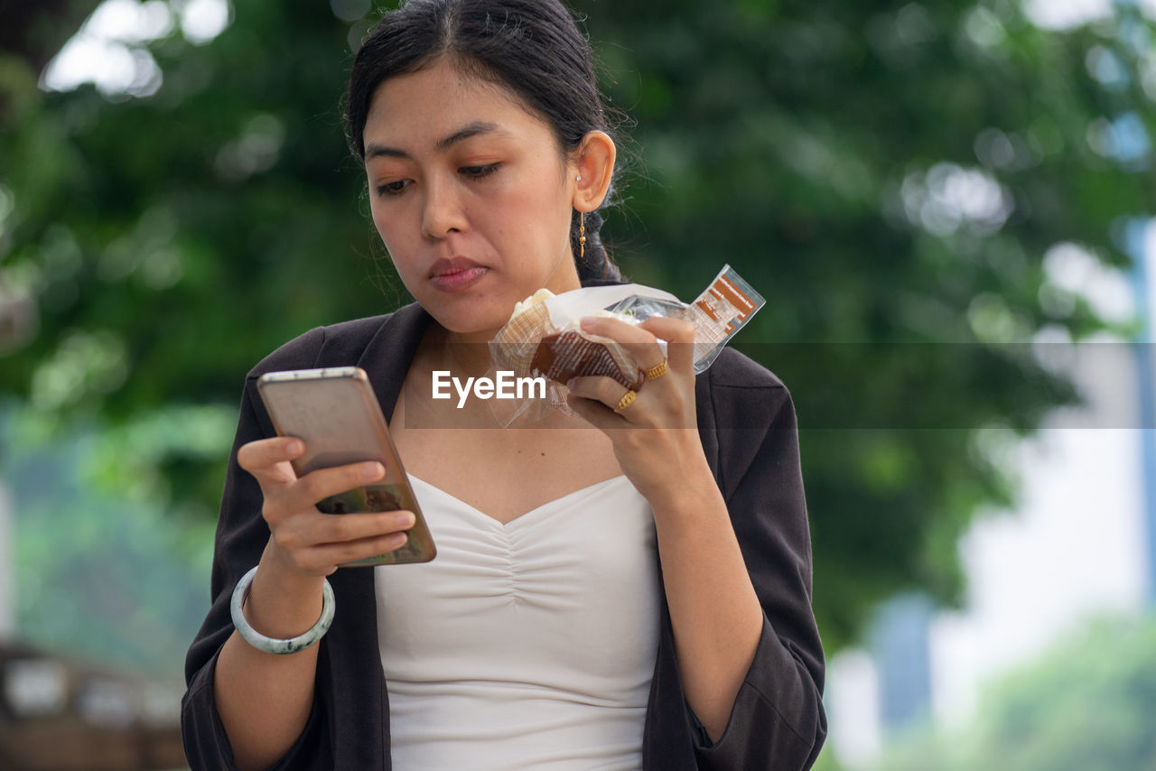 Young woman using smart phone outdoors