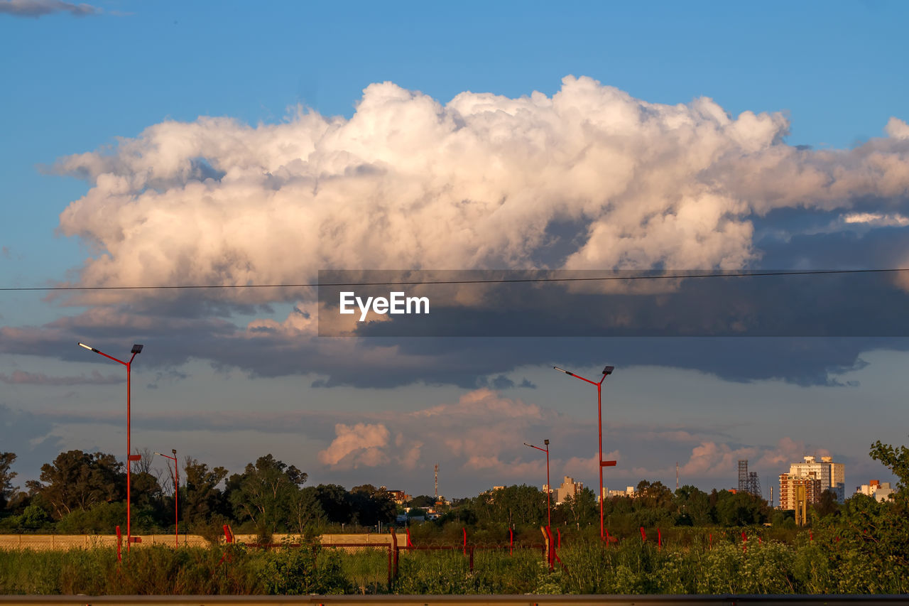 sky, cloud, nature, environment, dusk, horizon, tree, plant, no people, landscape, beauty in nature, outdoors, evening, electricity, land, rural area, sunset, technology, transportation, street, architecture, blue, scenics - nature, city, day, grass, road, social issues, wind, tranquility