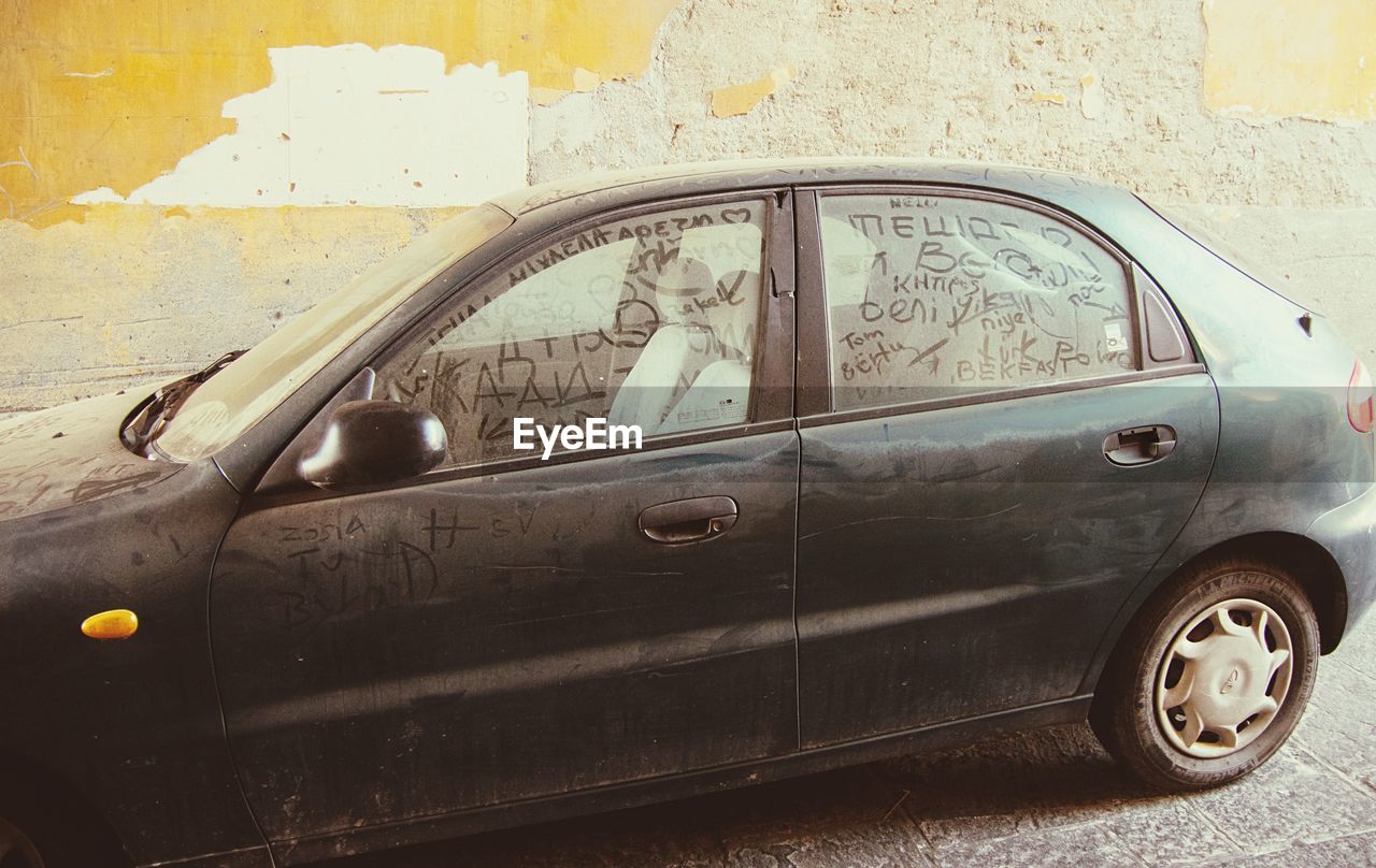 Text on car windows by wall