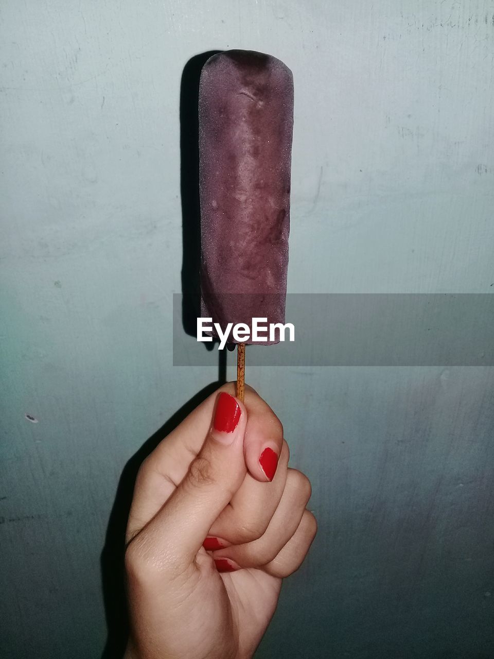 CLOSE-UP OF PERSON HOLDING ICE CREAM