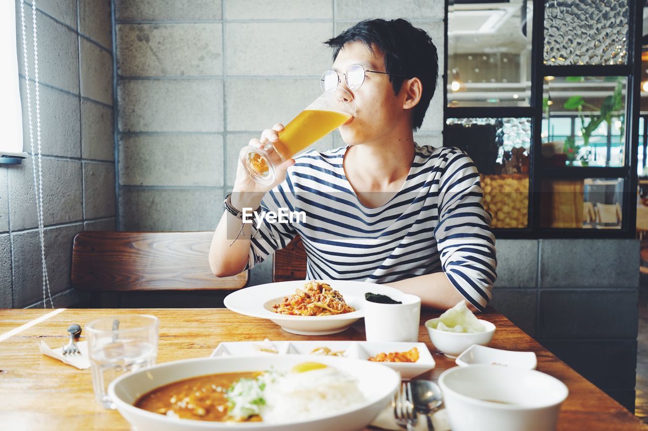 Man drinking beer while having lunch in restaurant