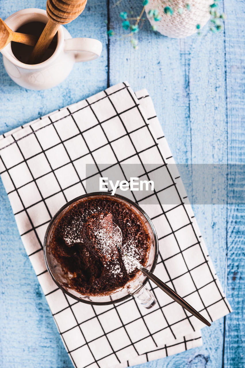 Homemade sweet cake in a mug made in the microwave on the table top and vertical view