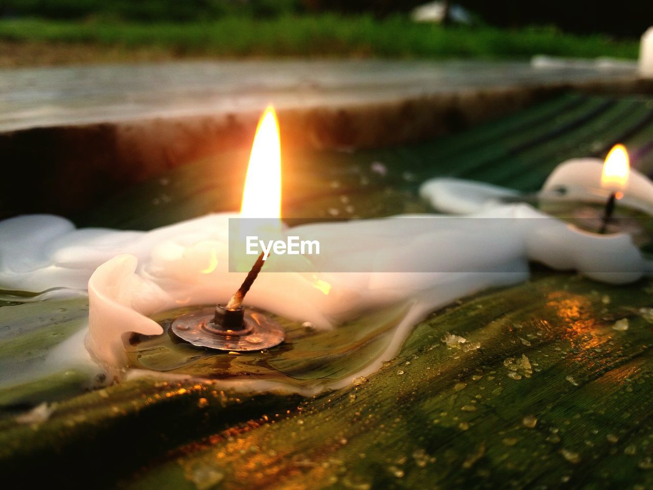 Close-up of illuminated candle on wood