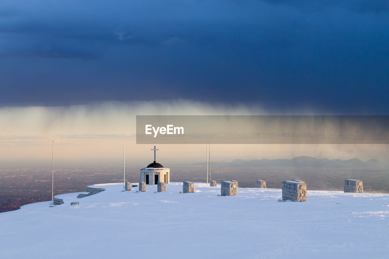 BUILT STRUCTURE ON SNOWCAPPED LANDSCAPE AGAINST SKY