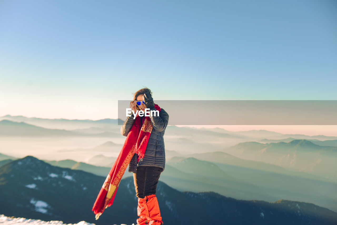 Man standing against mountain range against clear sky