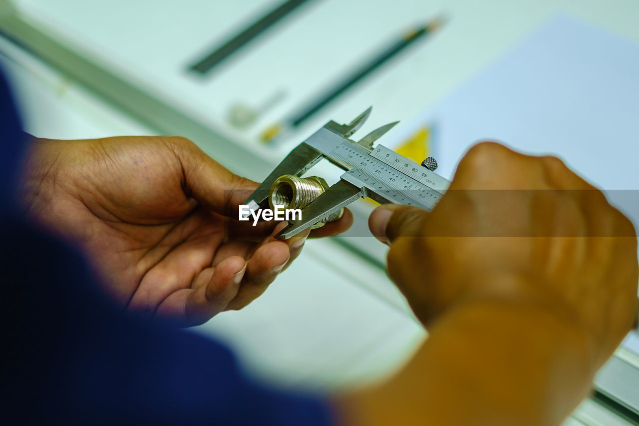 Cropped hands of man holding work tool