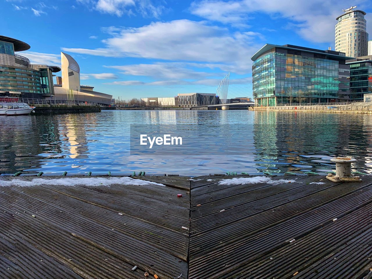 Pier by lake against sky in city