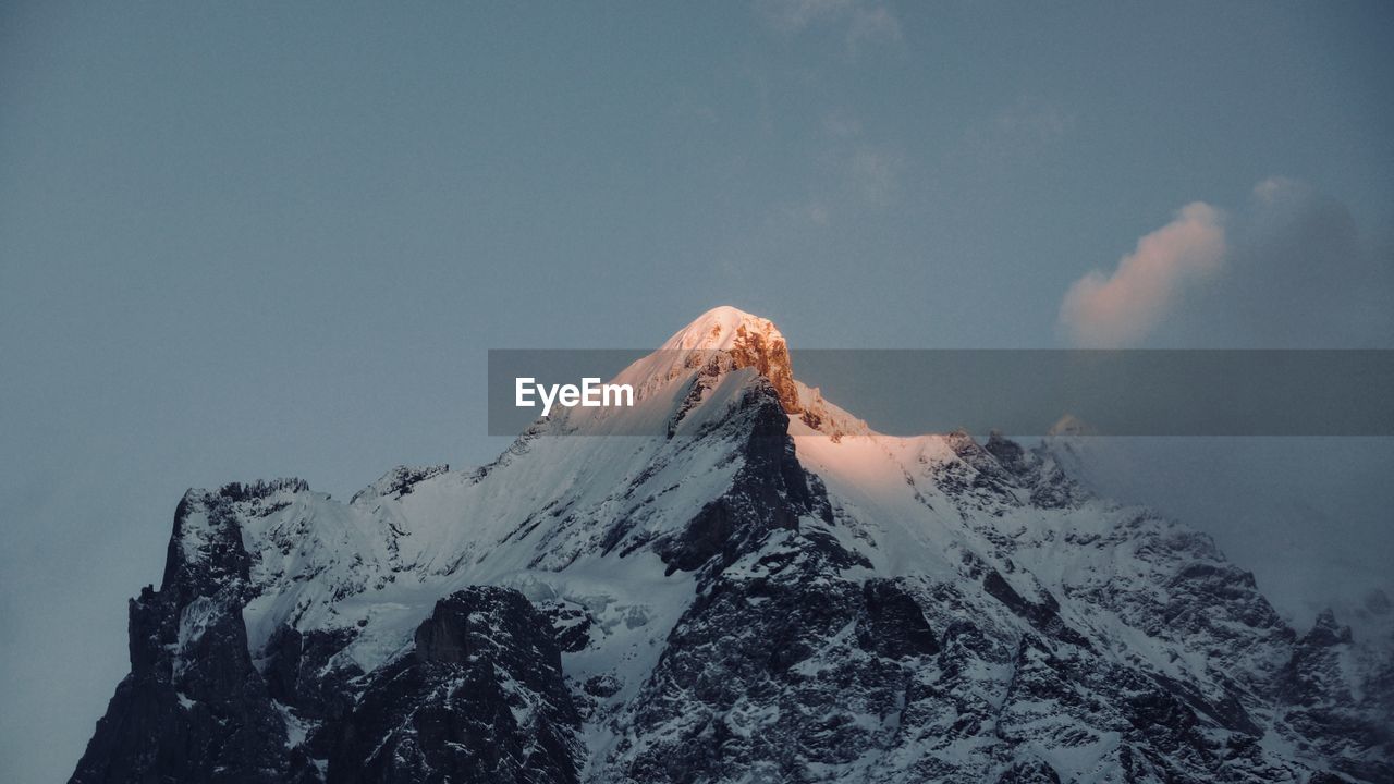 Low angle view of snowcapped mountains against sky