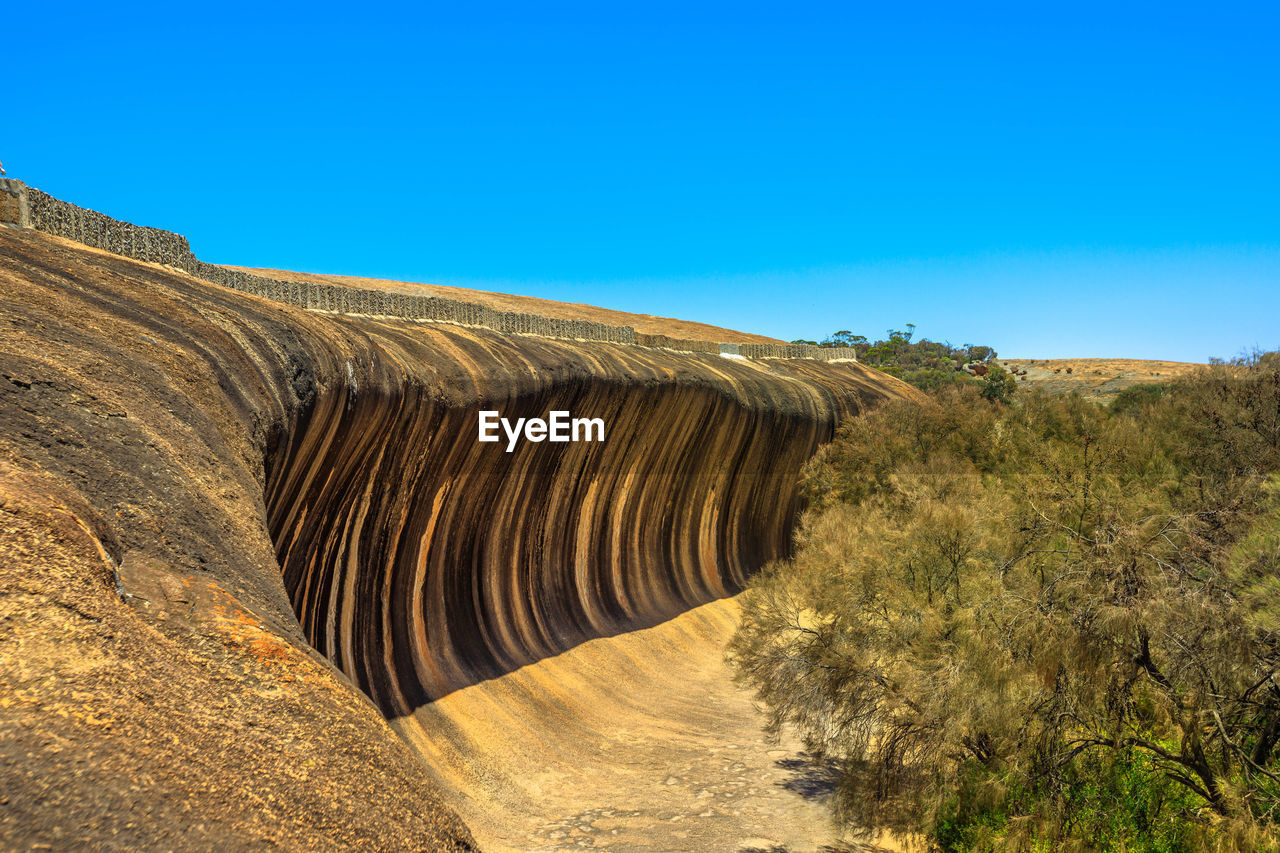 ROCK FORMATIONS ON LANDSCAPE AGAINST BLUE SKY