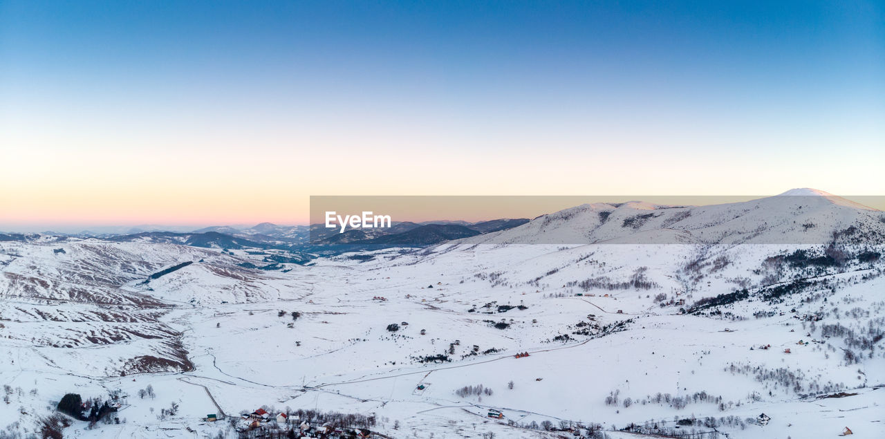 Scenic view of snowcapped mountains against clear sky