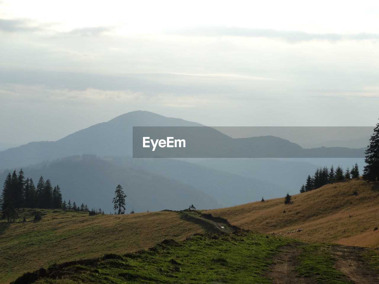 Scenic view of mountains against cloudy sky