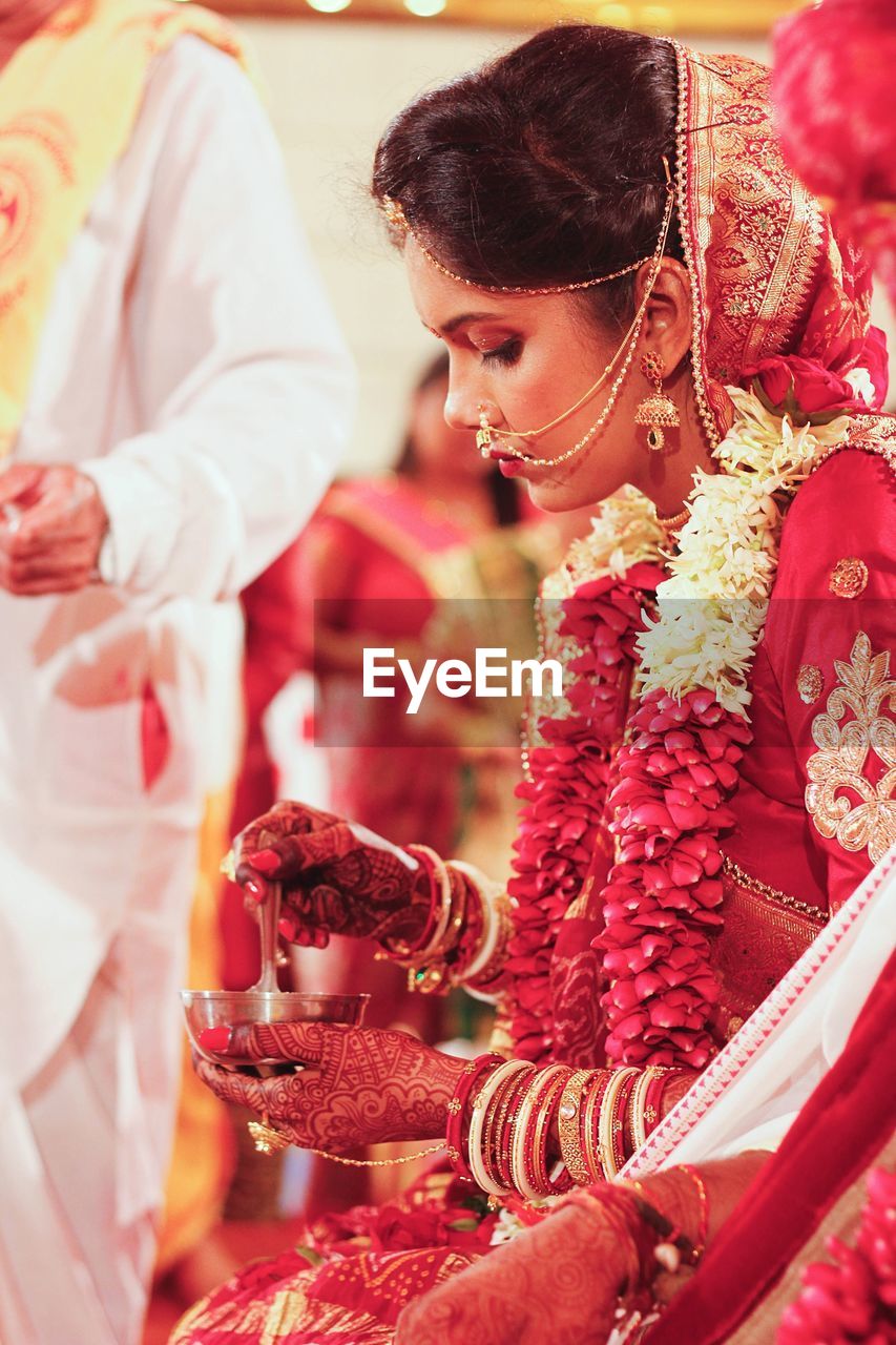 Midsection of bride performing rituals
