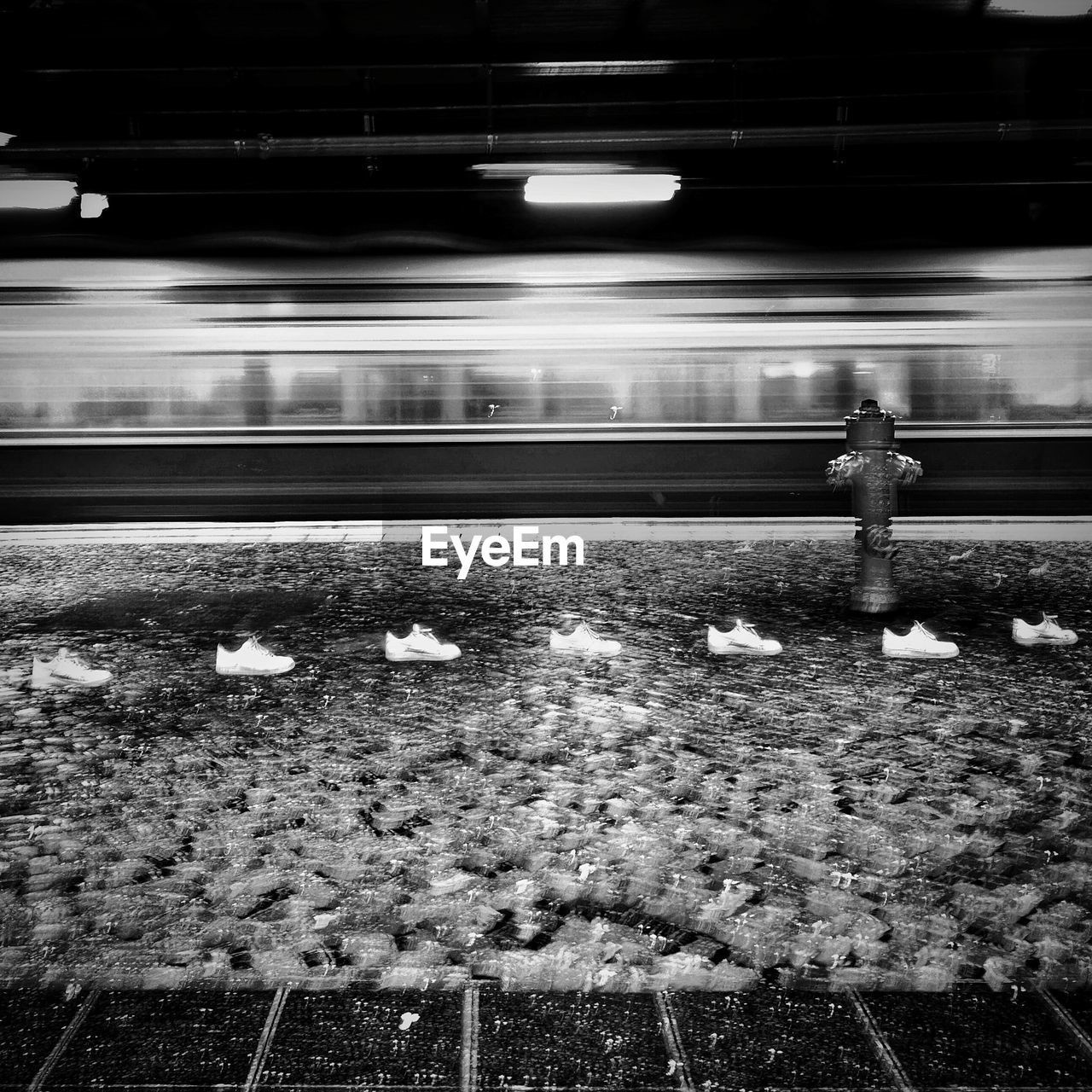 REAR VIEW OF MAN STANDING AT RAILROAD STATION PLATFORM