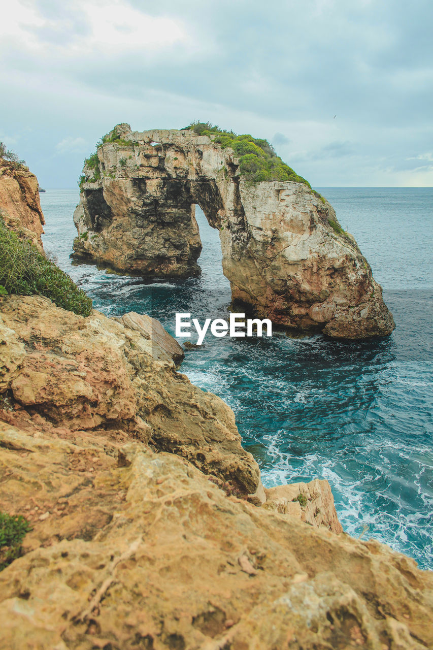 Rock formations in sea against sky