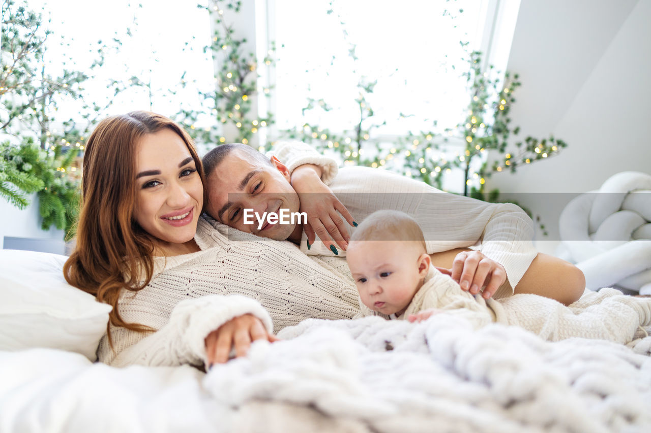 Portrait of young family on bed at home