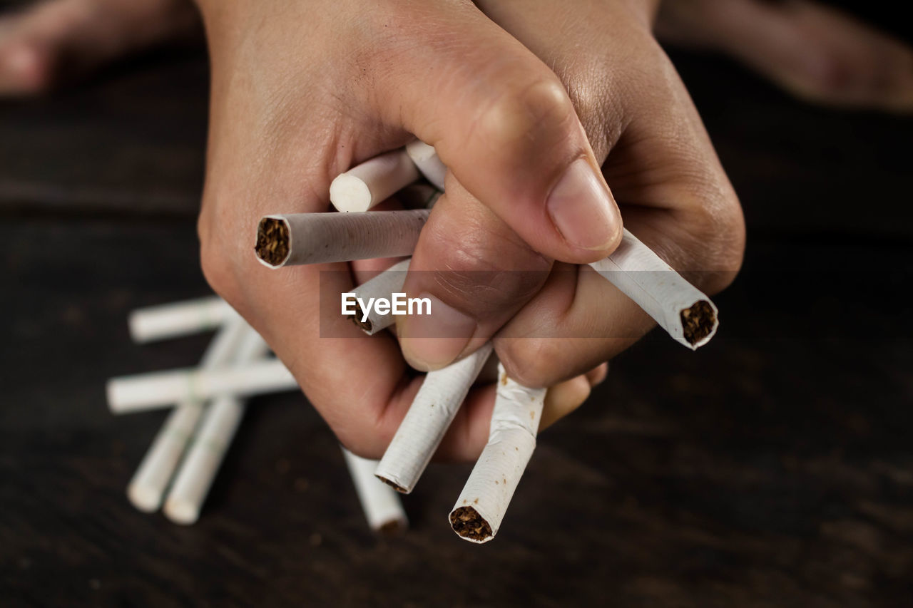 Cropped hand of woman holding cigarettes