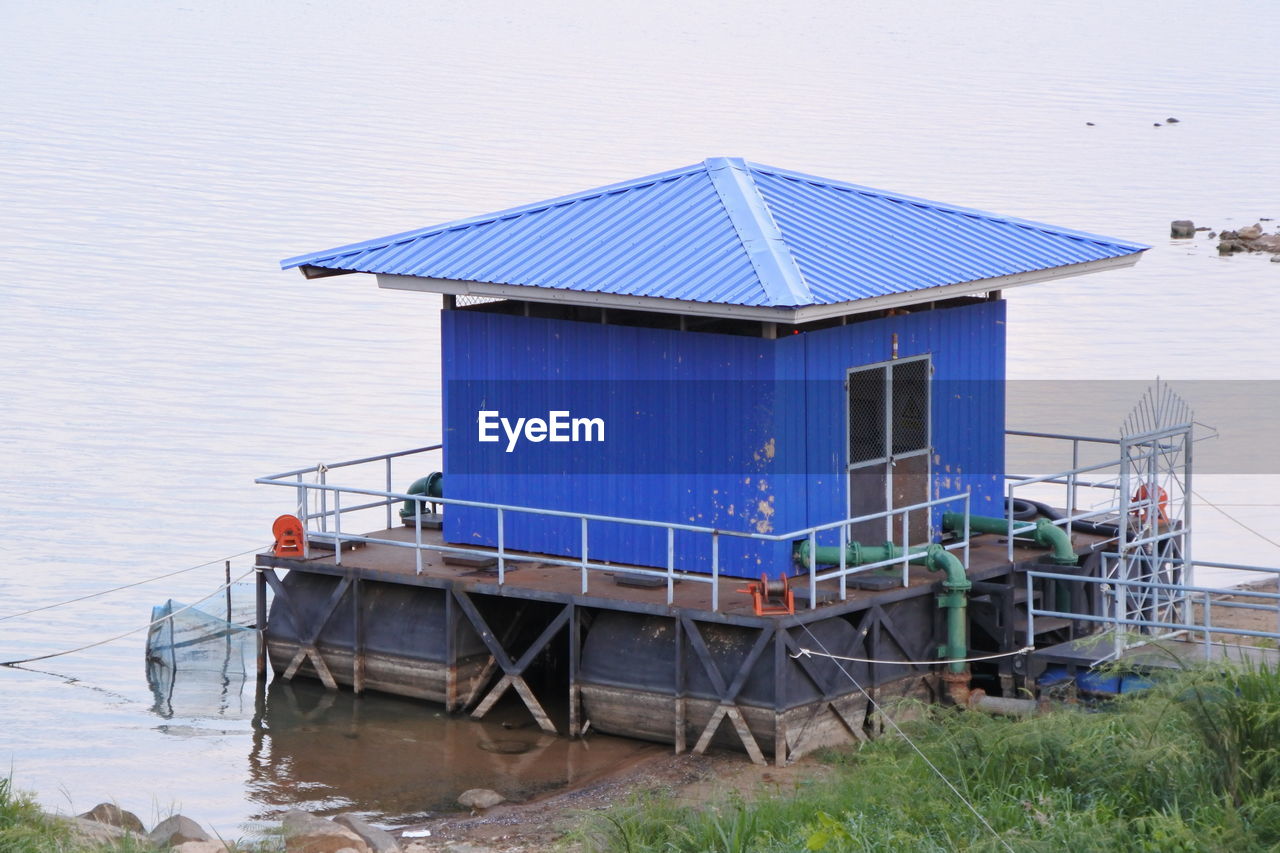 STILT HOUSE ON BEACH AGAINST SKY