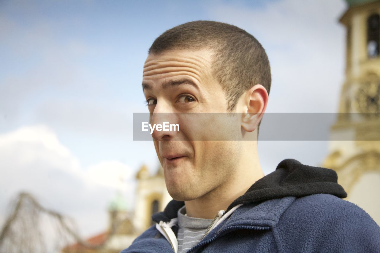 Portrait of young man making face while standing outdoors