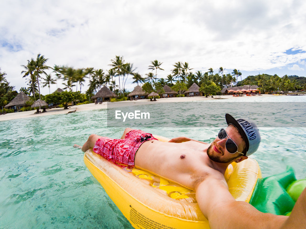 MAN IN BOAT ON BEACH AGAINST SKY