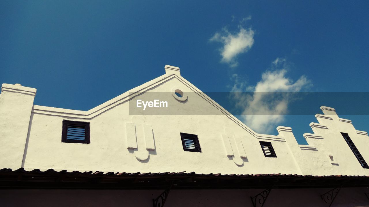 LOW ANGLE VIEW OF BUILDINGS AGAINST BLUE SKY